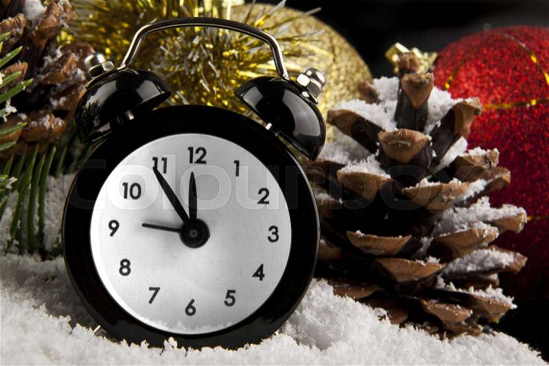 Clock, cone, Christmas decorations and snow on a black background, stock photo