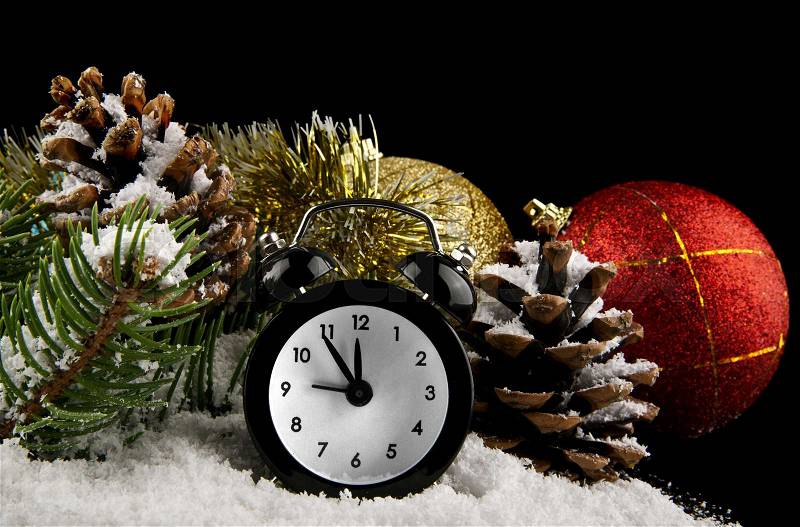 Clock, cone, Christmas decorations and snow on a black background, stock photo