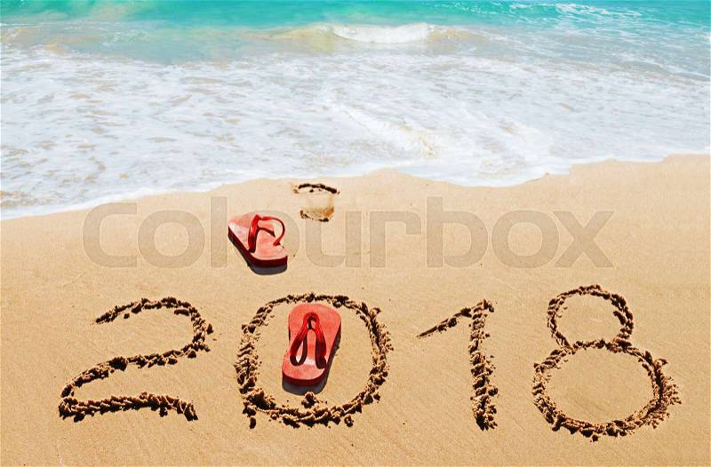Red flip flops and digits 2018 on the beach sand.Concept of summer vacations, new year and Christmas, stock photo