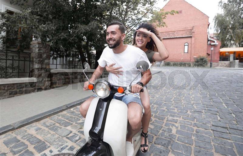 Happy young couple having fun on a scooter, stock photo