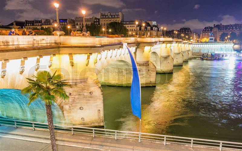 Tourists enjoy Seine river from Paris bridge at night, stock photo