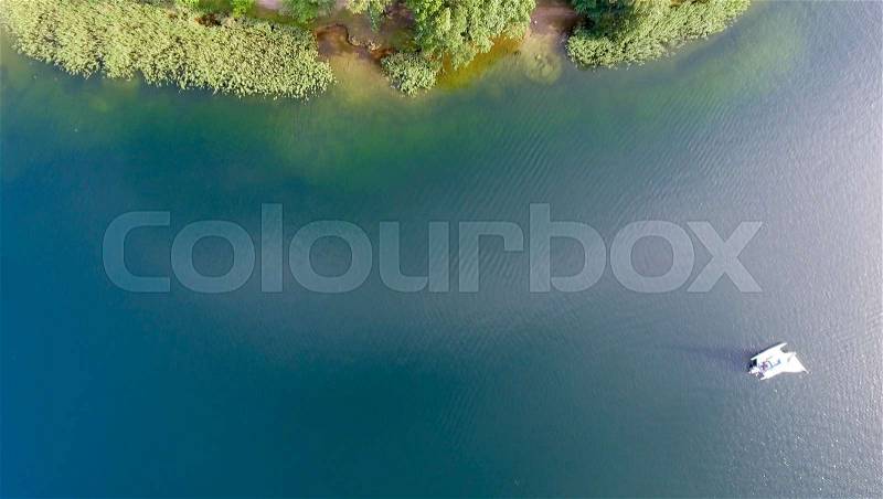 Overhead aerial view of lake with boat, stock photo