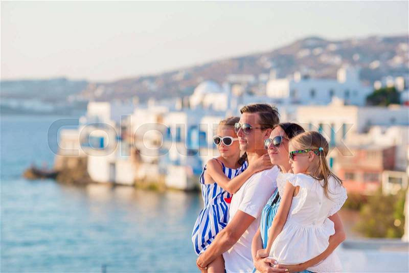 Family vacation. Parents and kids on Little Venice background on Mykonos Island, in Greece, Europe, stock photo
