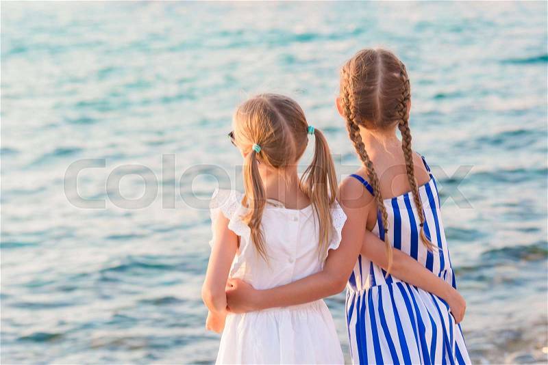 Adorable little girls at Little Venice the most popular tourist area on Mykonos island, Greece. Back view of beautiful kids look at Little Venice background, stock photo
