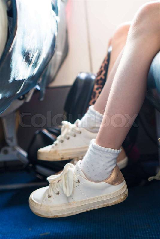 Closeup of baby feet on seat in the aircraft, stock photo