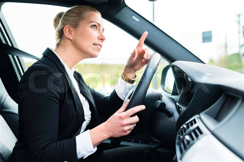 Woman driving car being angry cursing other driver, stock photo