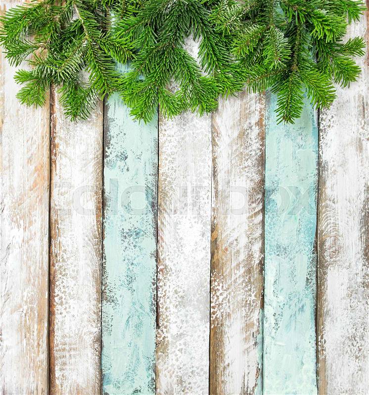 Christmas tree branches on colored rustic wooden background. Winter holidays, stock photo