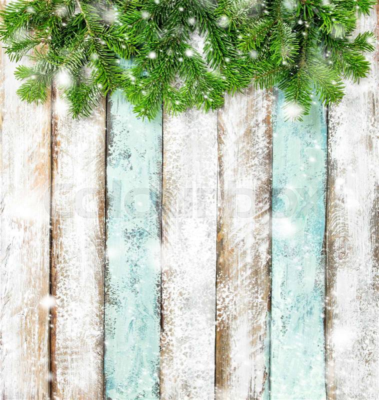 Christmas tree branches on rustic wooden background. Winter holidays banner with snow effect, stock photo