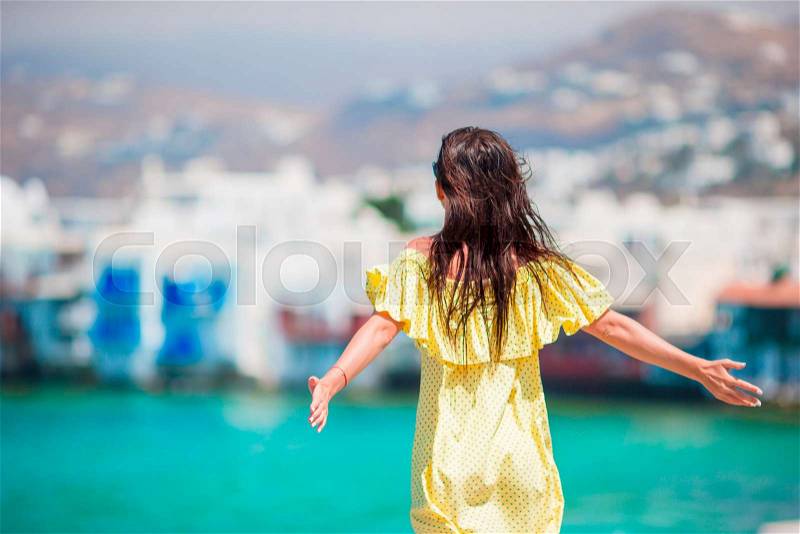 Happy young woman at Little Venice the most popular tourist area on Mykonos island, Greece. Beautiful girl enjoy greek vacation on Little Venice background, stock photo