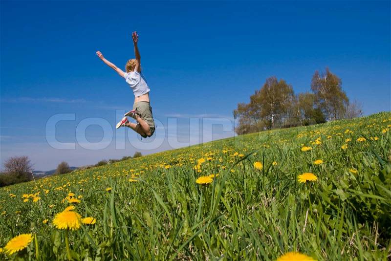 Young female having fun on flowery meadow, stock photo