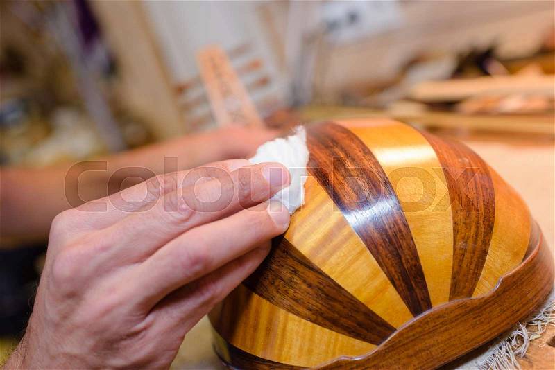 Hands polishing musical instrument, stock photo