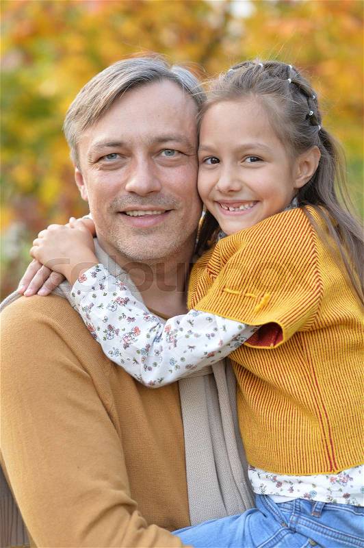 Portrait of father and daughter hugging outdoors, stock photo
