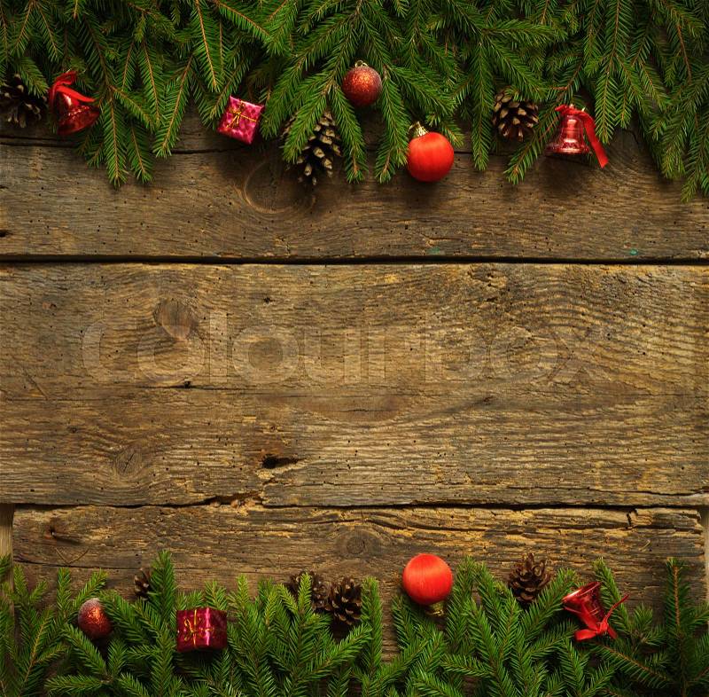 Christmas border with fir tree branches, cones and christmas decorations on rustic wooden boards ready for your design, stock photo