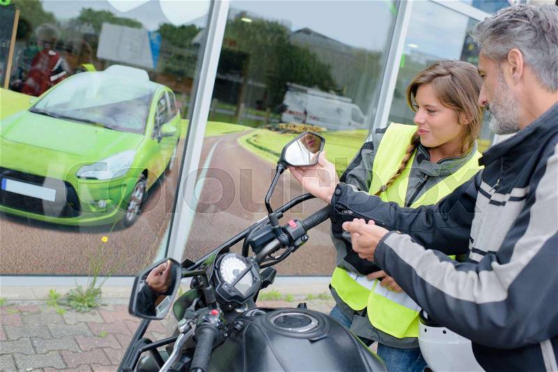 Lady preparing for driving lesson on motorcycle, stock photo