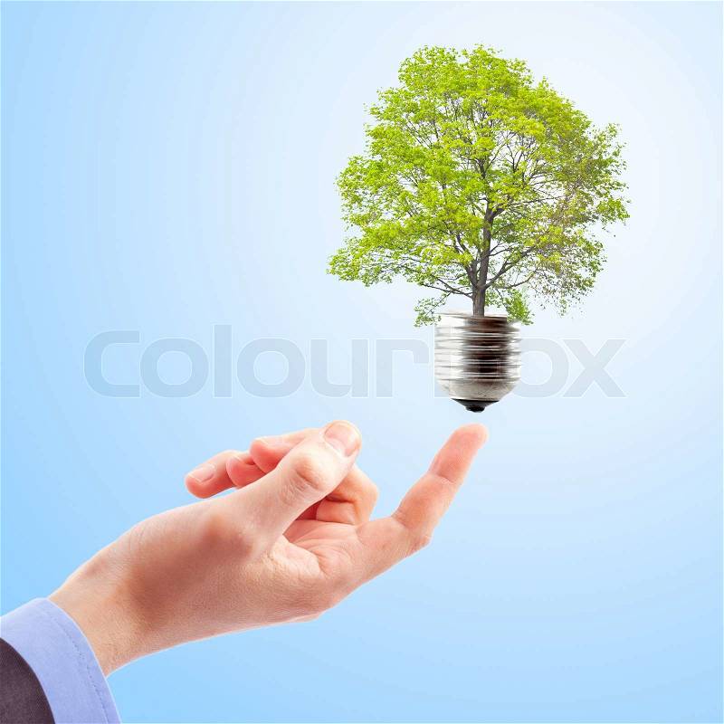 Hand with lamp and tree Concept of renewable energy, stock photo