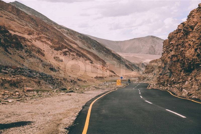 Asphalt road with traffic signs in Indian Himalayas, Ladakh region , stock photo