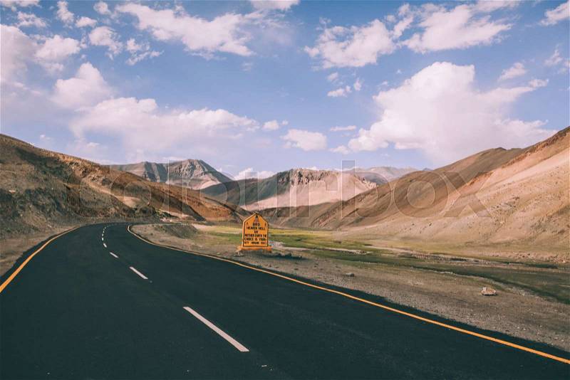 Asphalt road with traffic sign in Indian Himalayas, Ladakh region , stock photo