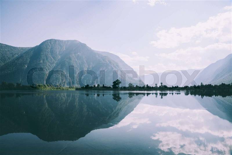 Majestic mountains reflected in calm mountain lake in Altai, Russia, stock photo