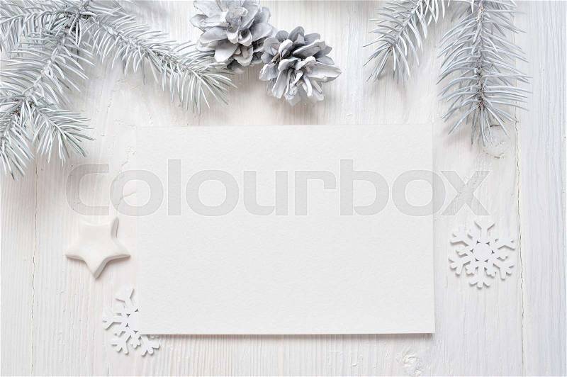 Mockup Christmas greeting card with white tree and cone, flatlay on a white wooden background, with place for your text, stock photo