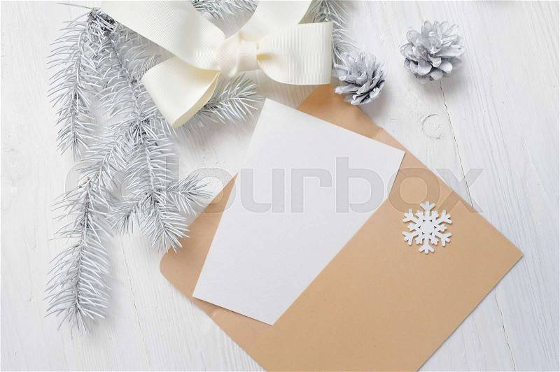 Mockup Christmas greeting card letter in envelope with white tree and cone, flatlay on a wooden background, with place for your text, stock photo