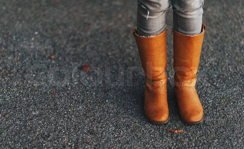 Tan tall leather boots on kid\'s feet, stock photo