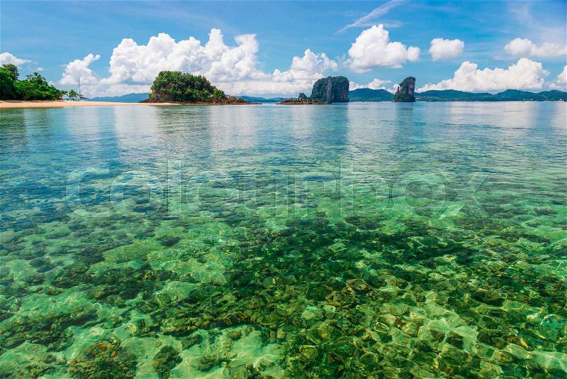 Transparent sea water, coral bottom and beautiful mountains on the horizon - beautiful scenery of Thailand, stock photo