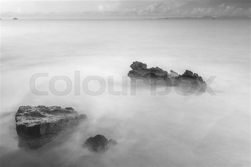 Black and white mystical photo - sea waves and cobblestones on the beach close up, stock photo