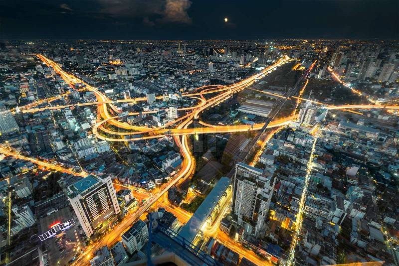 Brightly illuminated traffic intersection, roads and bridges at night view from above, stock photo