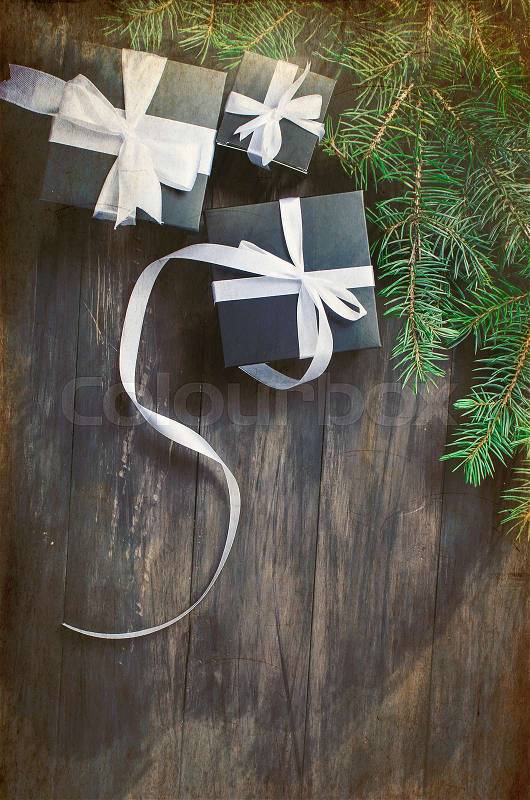 Black and white Christmas background. black gift box, balls, fir branches, silver Christmas decorations on the dark wooden background copy space, stock photo