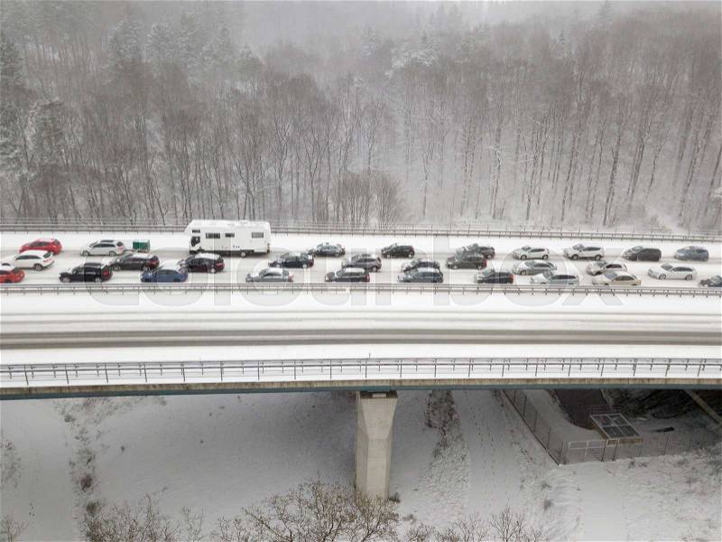 Cars on a highway bridge during a heavy snowfall in winter, stock photo