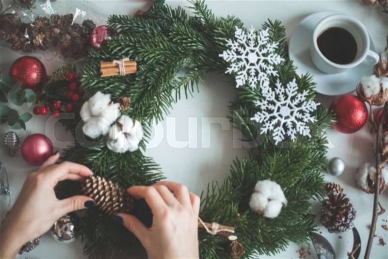 Christmas Garland with Female Hands, Cones, Evergreen Tree, Snowflakes and Xmas Balls. Decor for Christmas Home, stock photo