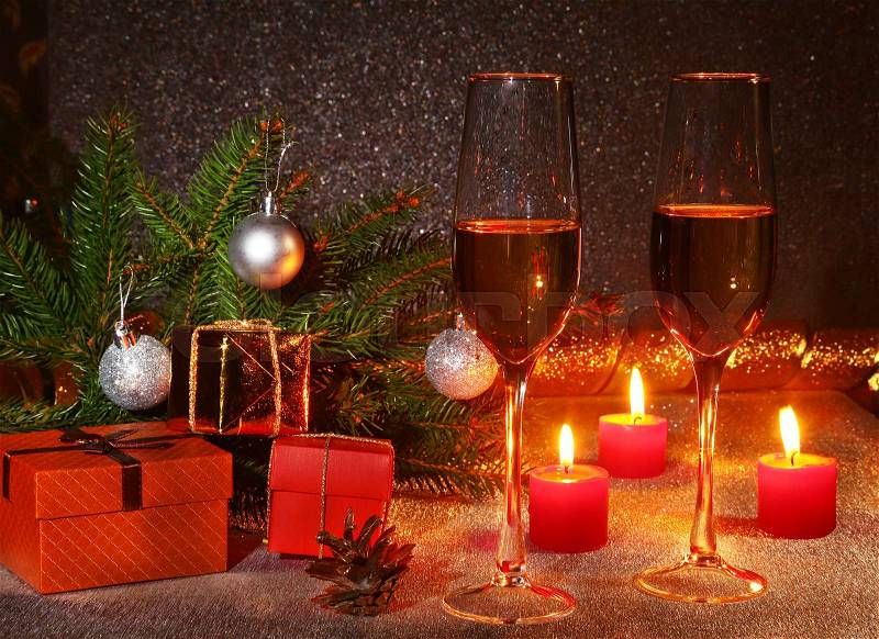 Christmas composition with Glass of sparkling champagne wine or cognac, christmas candles, colorful balls, gift box and tree on a sparkling background. New Year decoration, stock photo