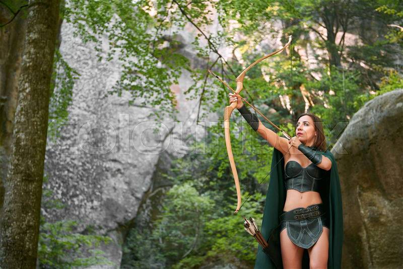 Shot of a mature female Amazon archer hunting in the woods with bow and arrows copyspace nature outdoors hunter tribe tribal traditional history character cosplay costume, stock photo