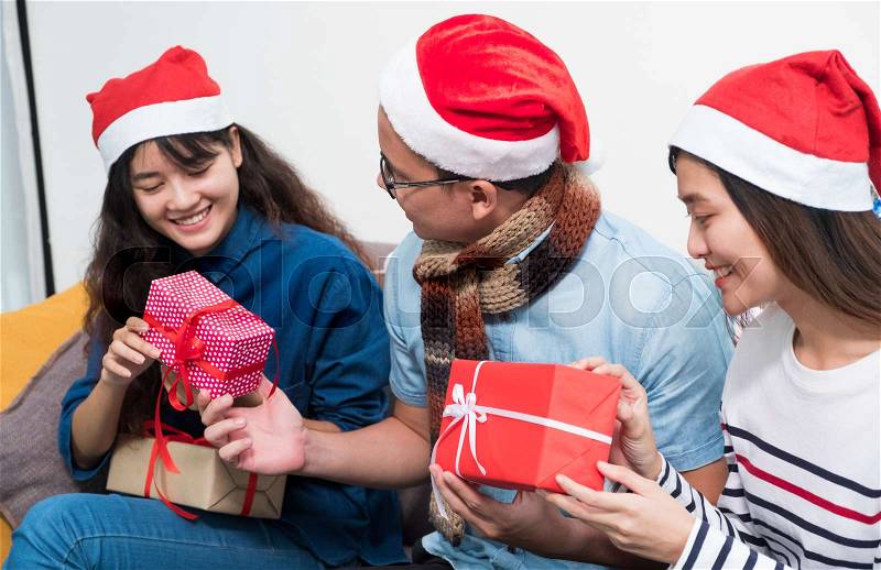 Christmas party with friends, asia people exchange gift and giving present with smiling face,Holiday xmas celebration concept, stock photo