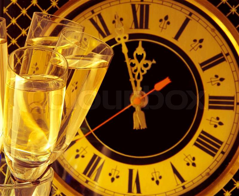 Christmas card Glasses of champagne on New Year\'s Eve against an ancient wall clock, stock photo