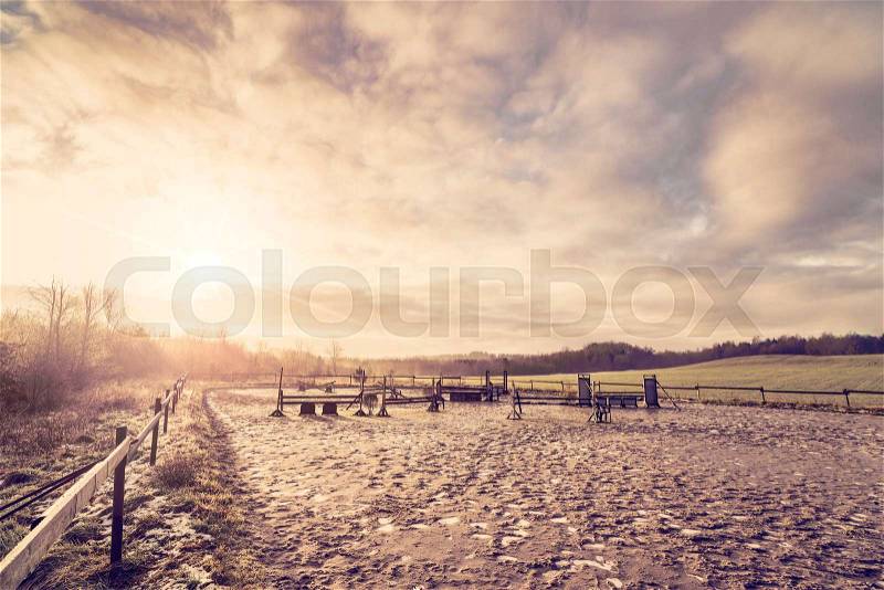 Horse equestrian course in the morning sunrise with frost on the muddy ground, stock photo