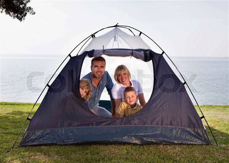 Family camping with tent by sea, stock photo