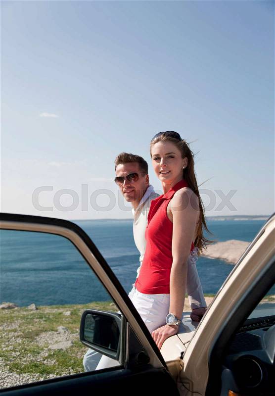 Couple with oldtimer by sea, stock photo
