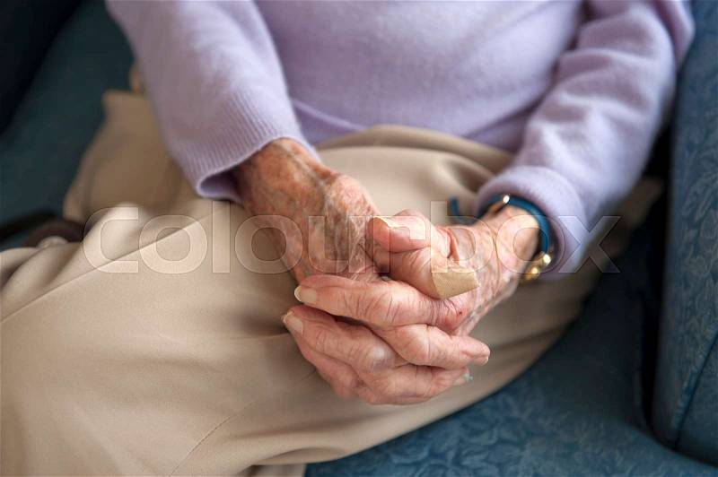 Old womans hands in lap, stock photo
