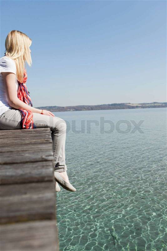 Woman sitting on a landing stage, stock photo