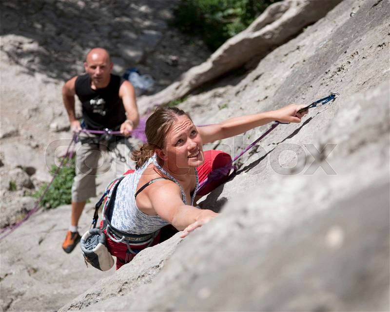 Rock climber climbing rock face, stock photo