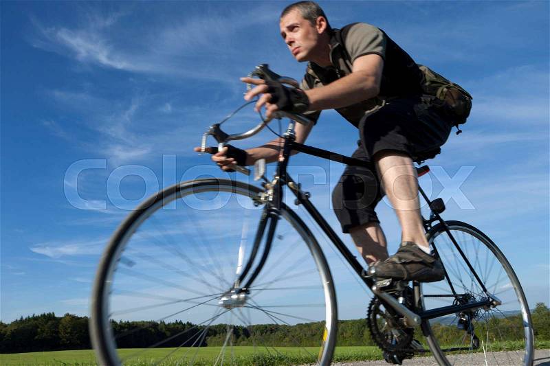 Man cycling fast with road bike, stock photo