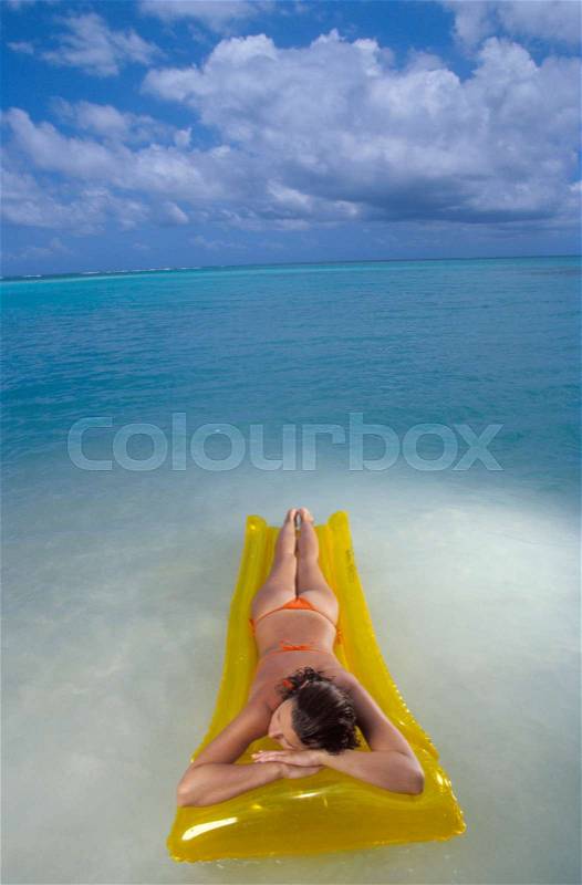 Woman laying on air mattress, stock photo