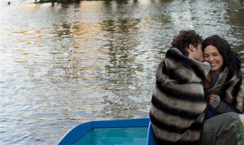 Man kissing woman on cheek on boat, stock photo