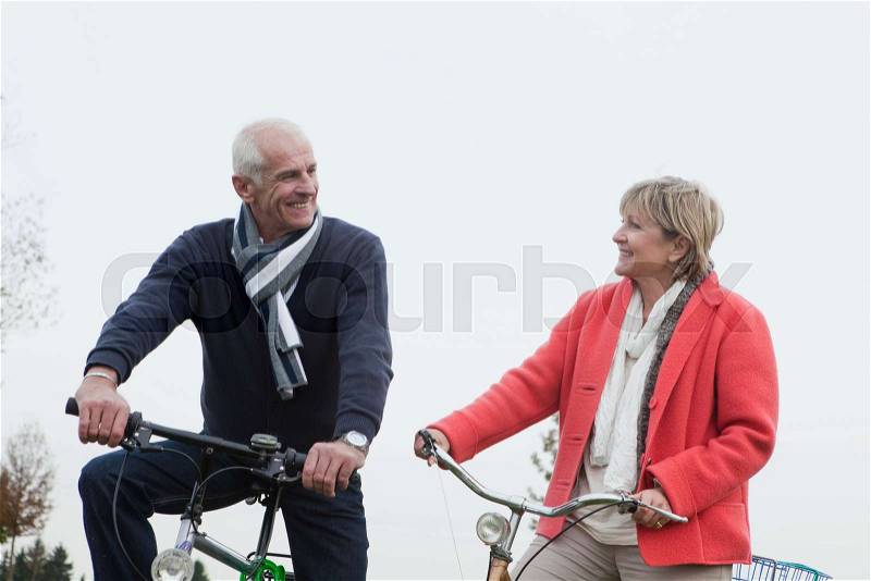 Senior couple riding bikes, stock photo