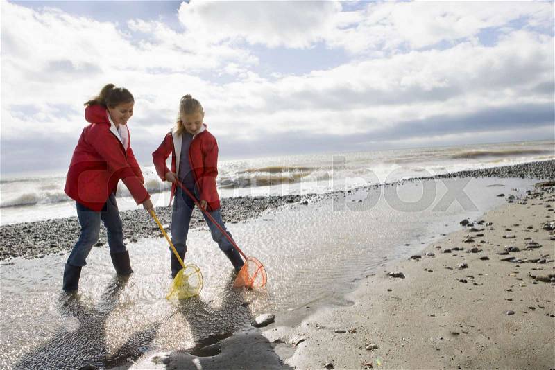 Mother and daughter fishing with fishnet, stock photo