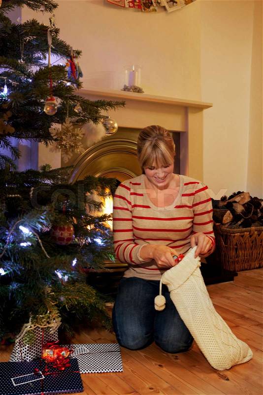 A woman reaching into a xmas stocking, stock photo