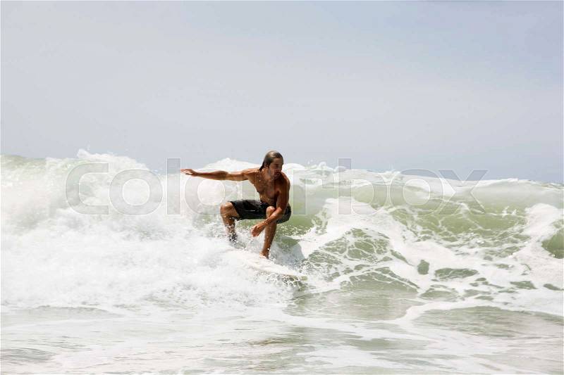 Guy surfing on wave, stock photo
