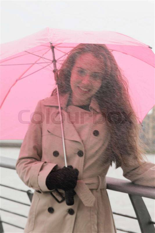 Young woman with umbrella in rain, stock photo