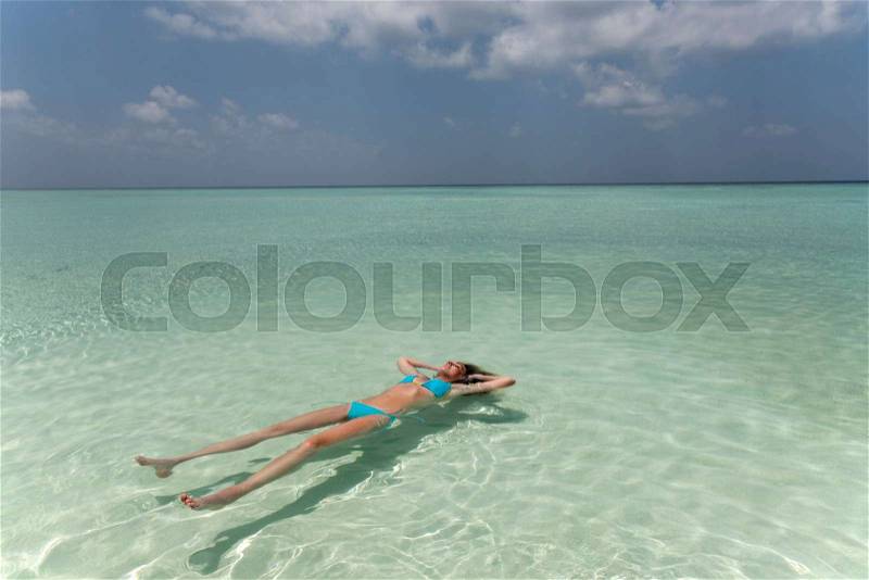 Woman floating in tropical sea, stock photo